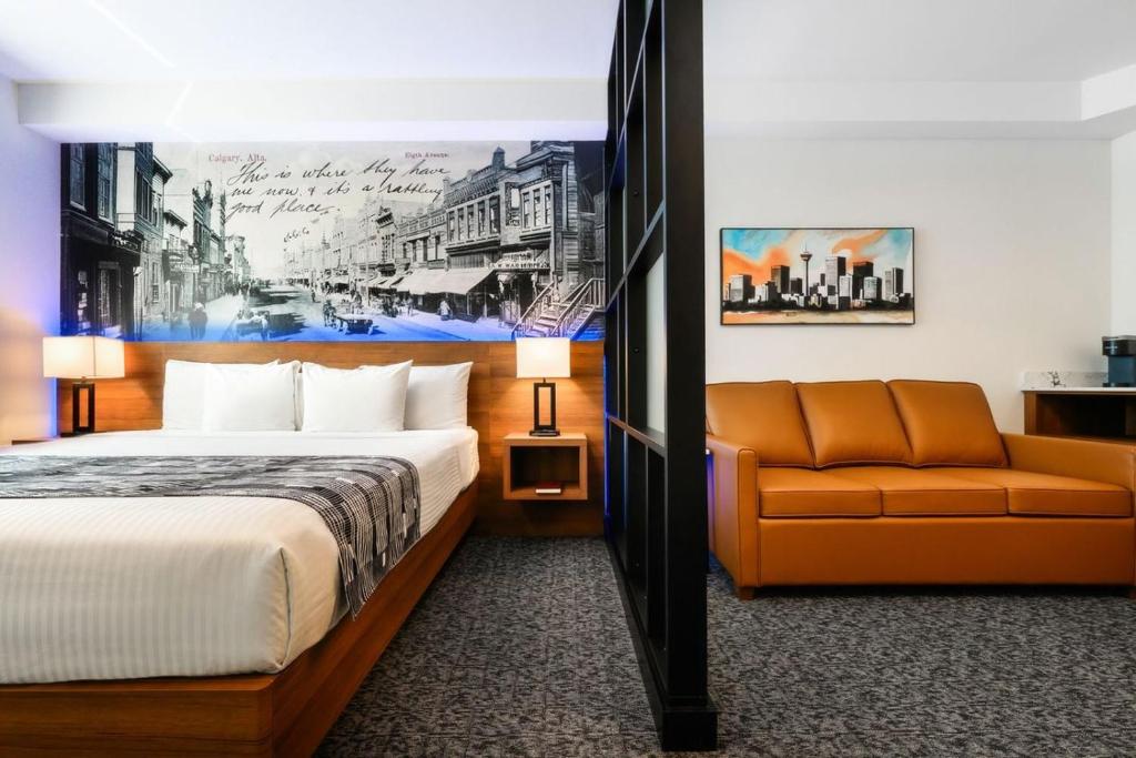 a hotel room with a bed and a couch at Acclaim Hotel by CLIQUE in Calgary