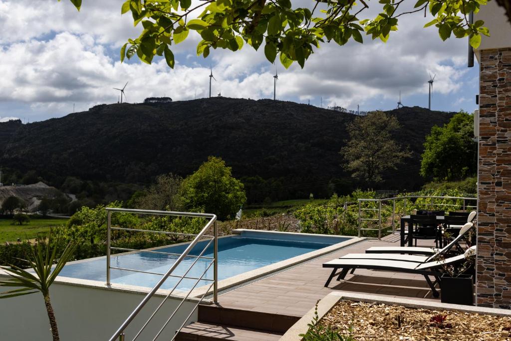 a house with a swimming pool with a mountain in the background at Casa Da Eira Caramulo in Varzielas