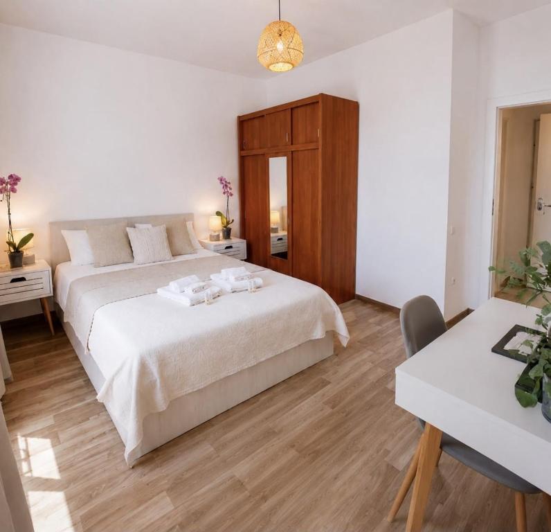 a bedroom with a large white bed and a table at Mountain View Apartment in Sibiu