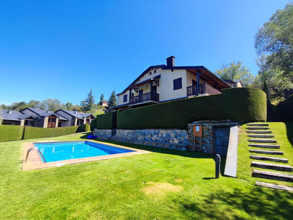 a house with a swimming pool in the yard at Apartamento con piscina en Osseja in Osséja