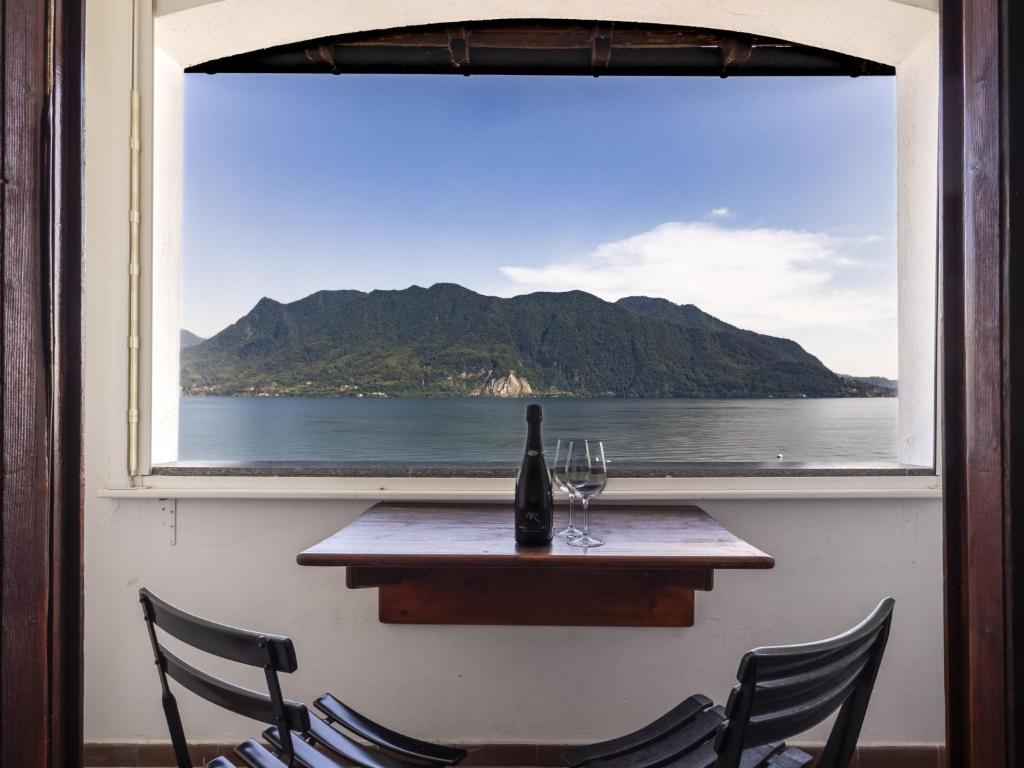 a bottle of wine sitting on a table in front of a window at Apartment Leonard Lake by Interhome in Ghiffa