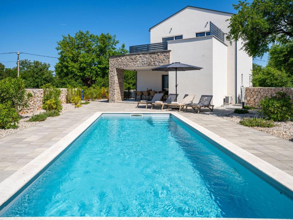 a pool in the backyard of a house with a villa at Villa Dream by Interhome in Dobrinj