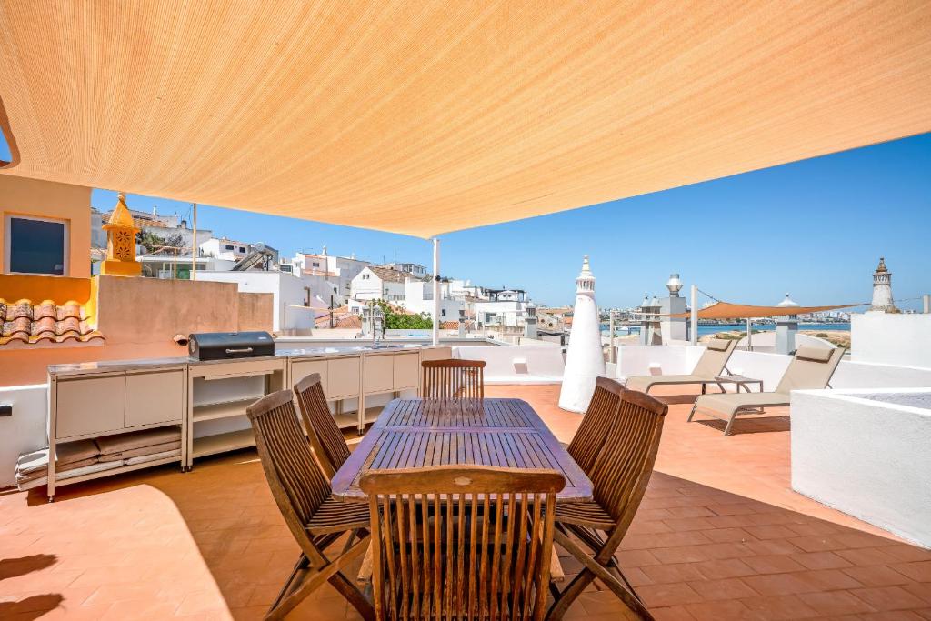 a patio with a table and chairs and a kitchen at BeGuest Ferragudo Sunny Apartment in Ferragudo