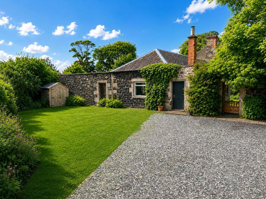a stone house with a gravel driveway at Ivy golf cottage in Leven