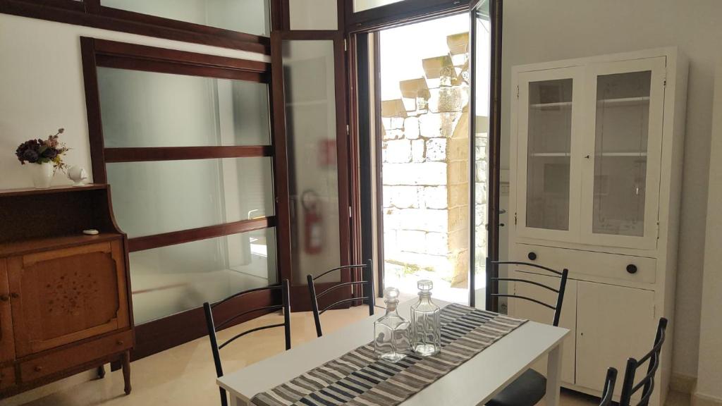 a table with chairs and a table and a window at Casa Ferrante in Lecce