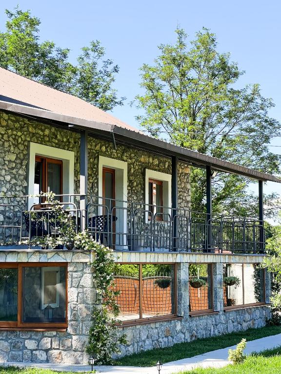 a stone house with a porch and balcony at Konoba Stanisic in Balabani
