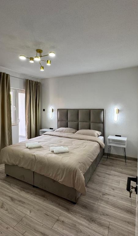 a bedroom with a large bed with two towels on it at Apartmani SARA Bugojno in Bugojno