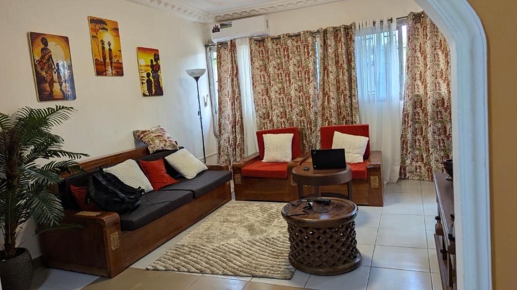 a living room with a couch and two chairs at LANISCA'S Home in Yaoundé