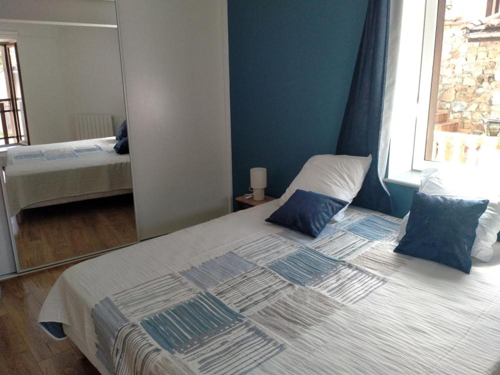 a bedroom with a bed with a mirror on it at La petite maison in Marchampt
