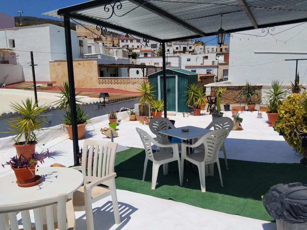 a patio with tables and chairs on a roof at La casita de la vito in Illar