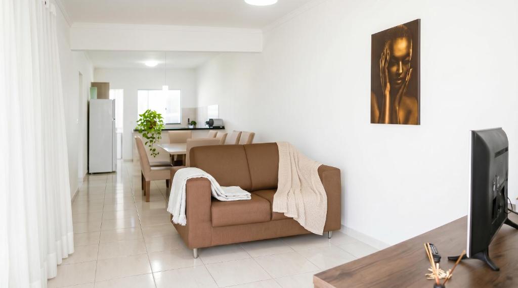 a living room with a couch and a television at Apartamento na Sapetinga - Melhor Pôr do Sol da cidade e com 3 Quartos in Ilhéus