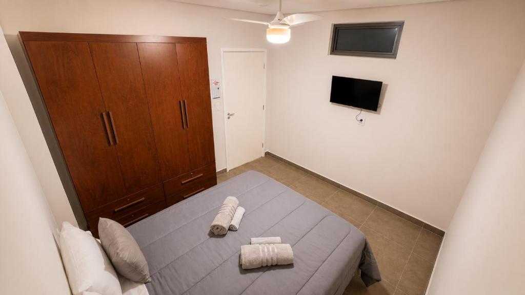 a bedroom with a bed and a wooden cabinet at Casa de Hóspedes Jaú in Jaú