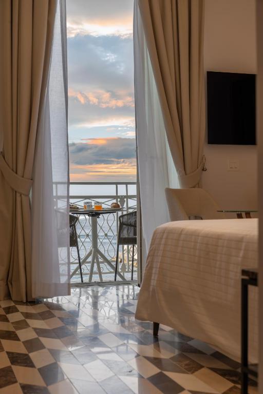 a hotel room with a bed and a view of the ocean at Bambagina Mare in Amalfi