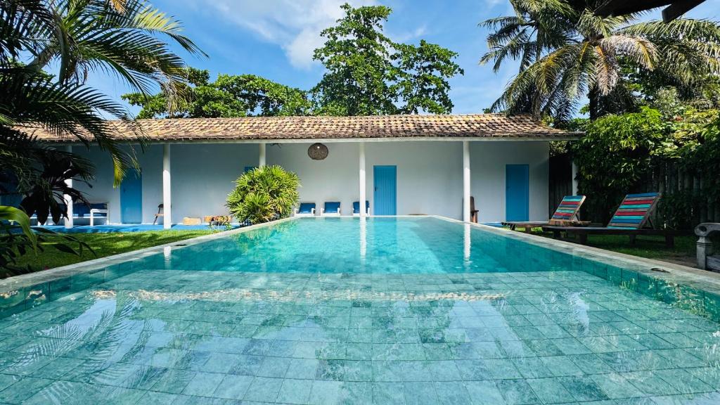 a swimming pool in front of a villa at Pousada Caraíva in Caraíva