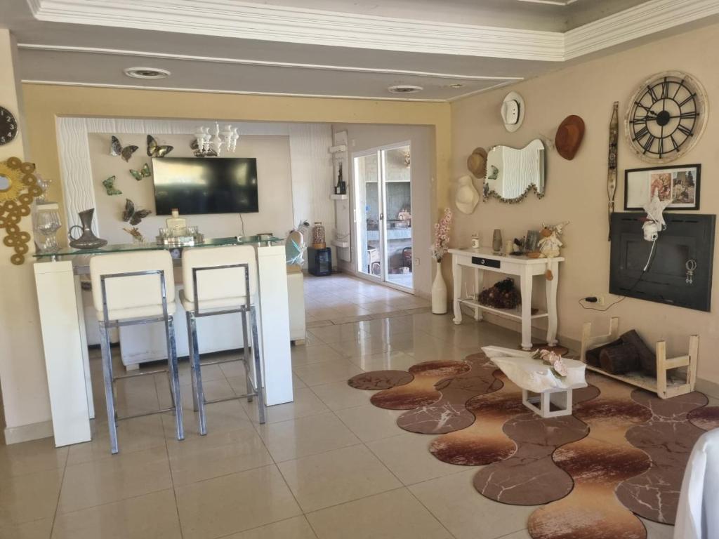 a living room with a table and a kitchen with a rug at Casa AONIKENK in Villa Dolores