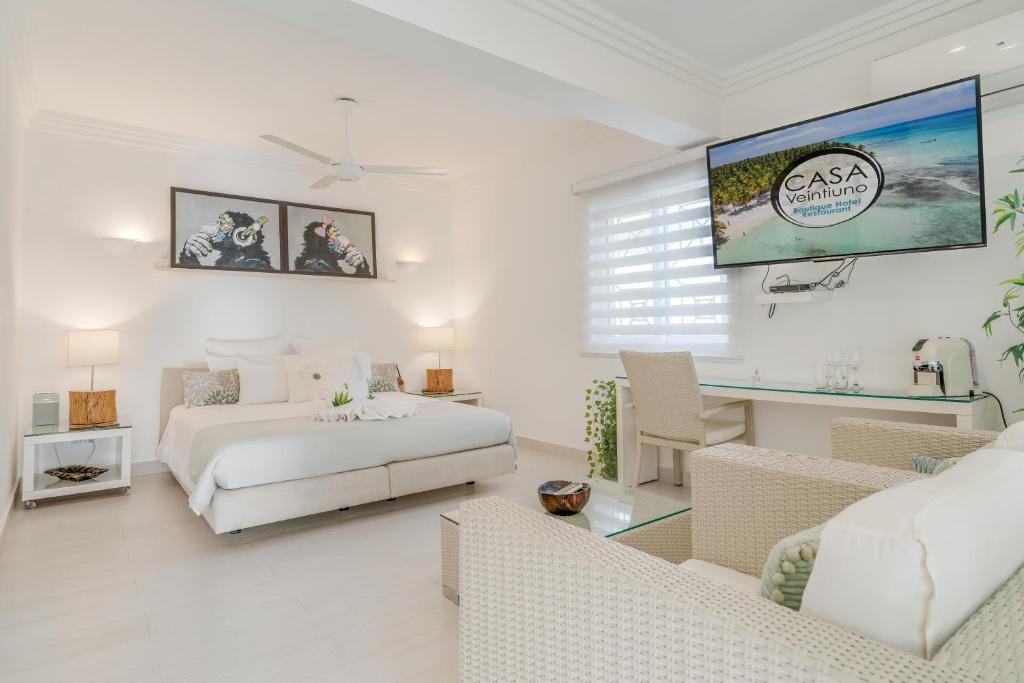 a white bedroom with a bed and a couch at Casa Veintiuno in Sosúa
