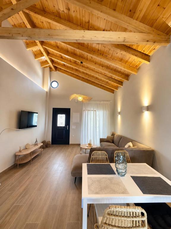 a living room with a couch and a table at Olea Verde Loft Apartment in Lefkimmi