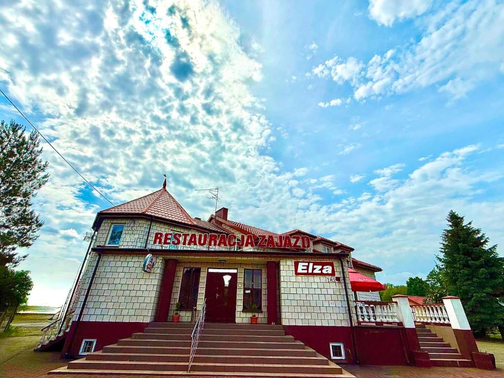 a red and white building with steps in front at Zajazd-Restauracja ELZA in Kutno