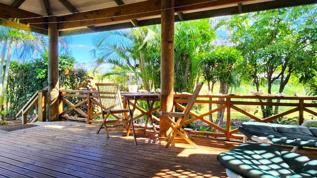 a wooden deck with a table and chairs on it at Aroa Kainga Bungalows and Apartment in Rarotonga