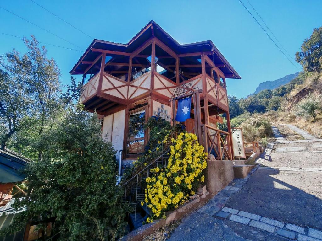 a small house with yellow flowers in front of it at Hostal Chikiyan in San José de Maipo