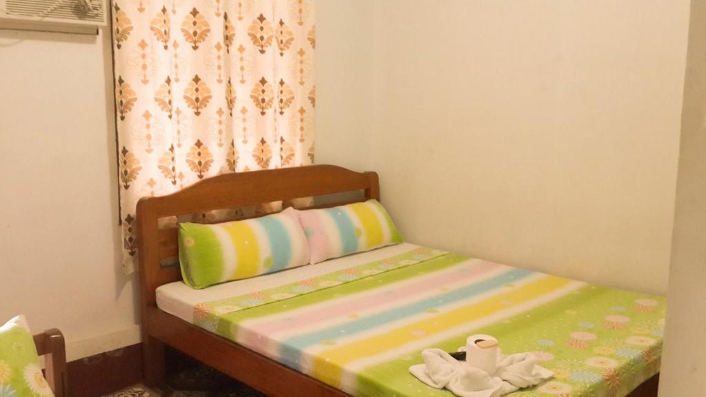Cama pequeña en habitación con cortina en Eden Travellers Lodge, en Puerto Princesa City