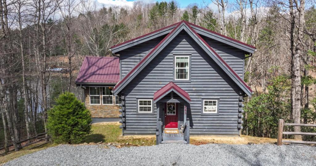 a black house with a red door in the woods at Lakin' it Easy! - Powder Horn Mountain in Powderhorn Mountain