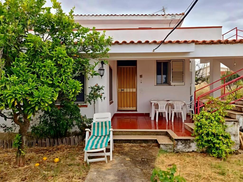 a house with a porch with a chair and a table at Casa vacanze a Roccella Jonica in Roccella Ionica