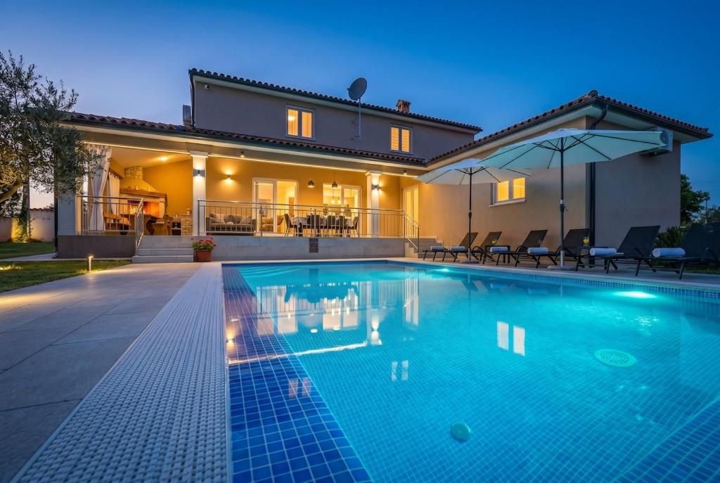 a large swimming pool in front of a house at Villa Karla, private pool, 3 bedroom in Divšići