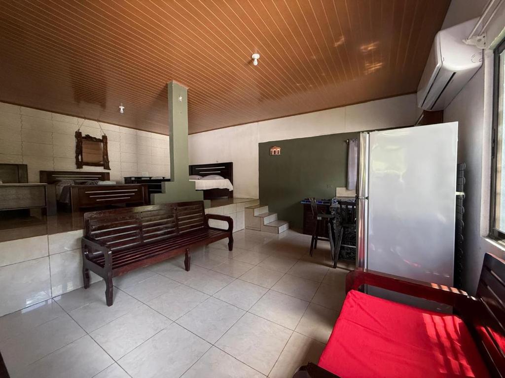 a waiting room with a bench and a kitchen at Cabinas Chinchilla in Quepos