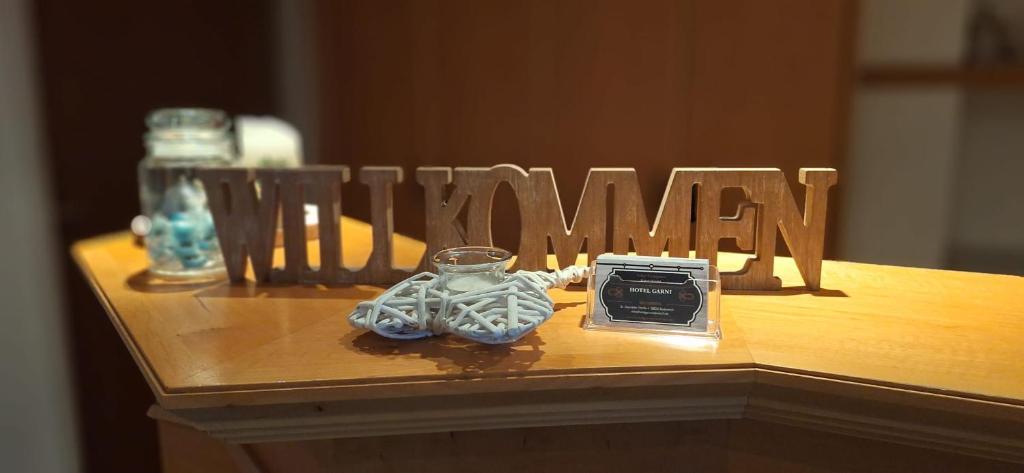 a wooden sign that says woman with a clock on a table at Hotel Garni in Rodewisch