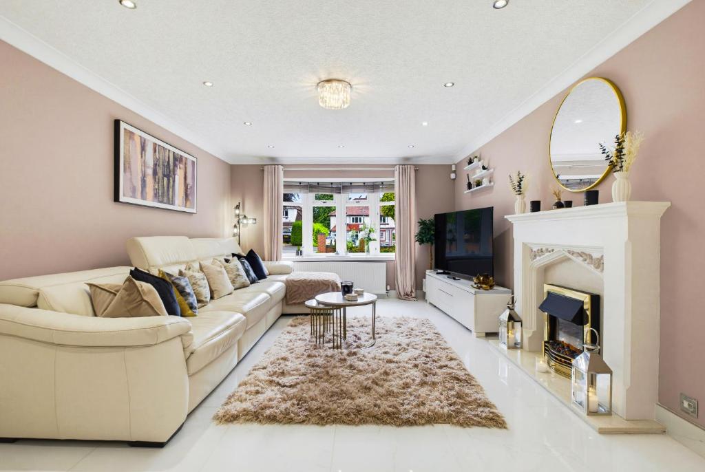 a living room with a white couch and a fireplace at Spacious 4BR with Parking for Groups & Contractors in Solihull