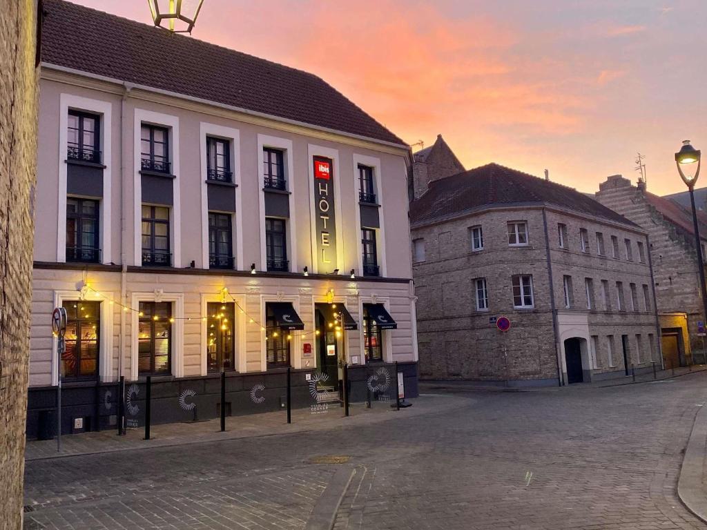 a large white building with a red sign on it at ibis Saint-Omer Centre in Saint-Omer