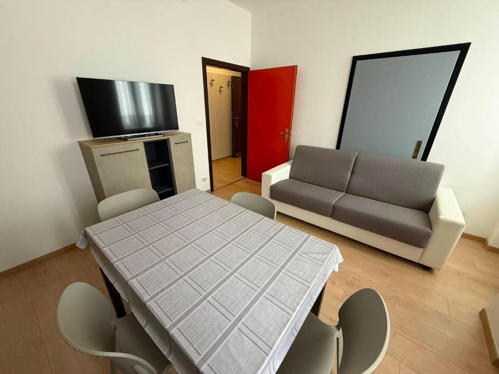 a living room with a table and a couch at Casa Lina in Cavalese