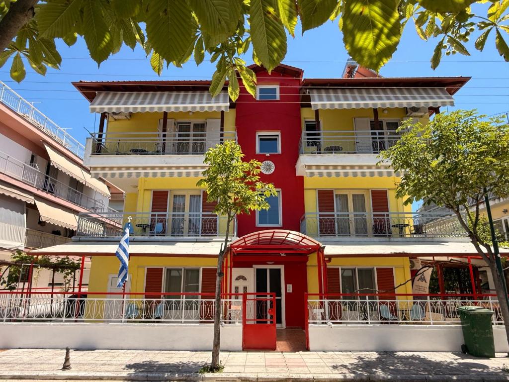 a red yellow and white building with a flag at Amphitrite's Paradise Apartments in Olympic Beach