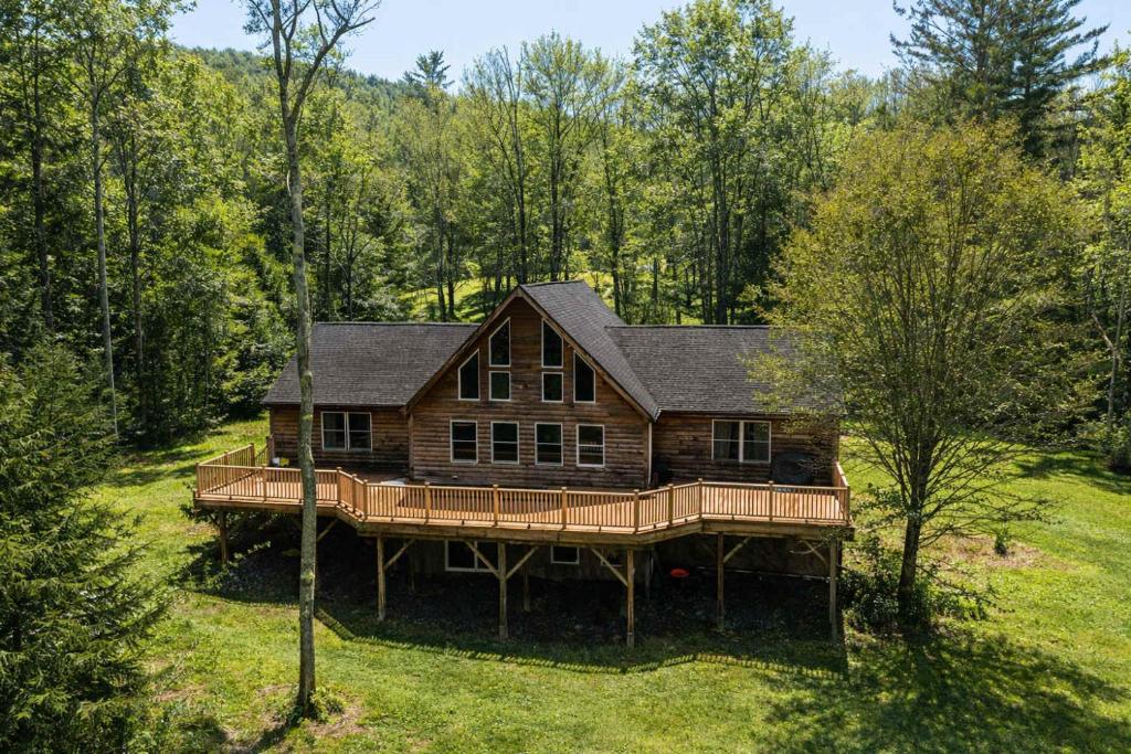 a large wooden house in the middle of a field at Kaaterskill Mountain House - 287 Acres with Fire Pit in Elka Park