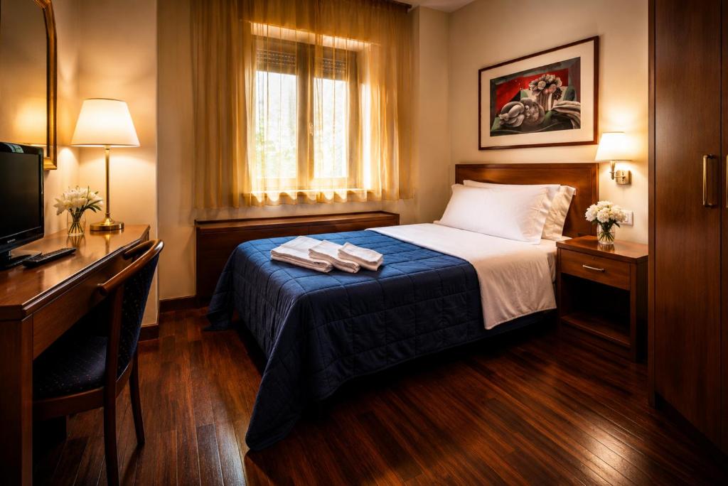 ein Hotelzimmer mit Bett und Schreibtisch in der Unterkunft Hotel Posta in Cecina