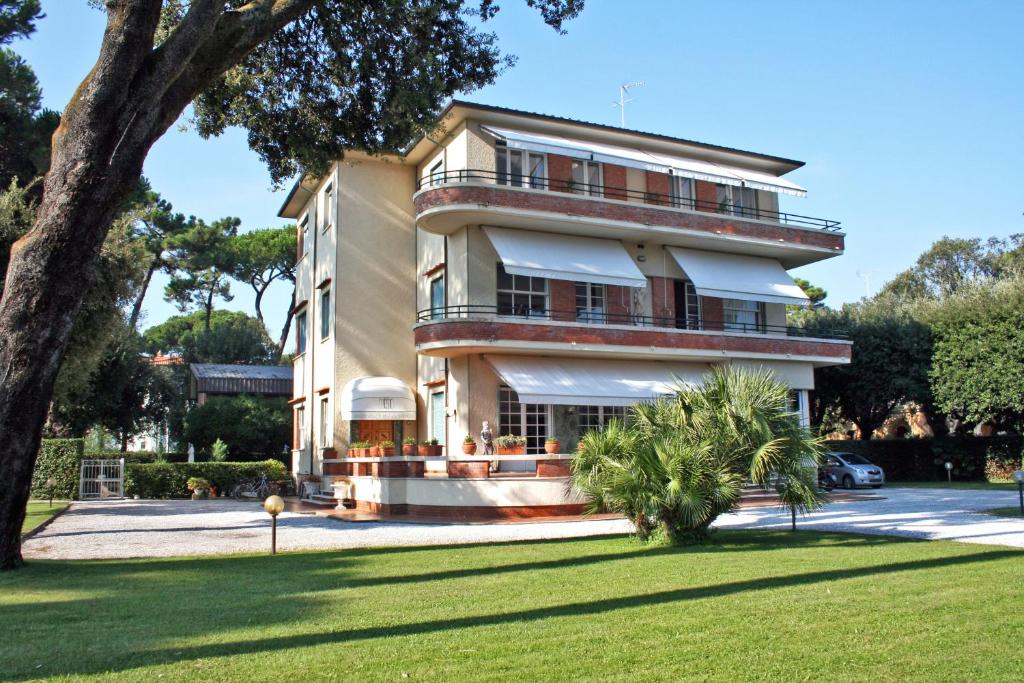 un grande edificio con un albero di fronte di Hotel Villa Edera a Marina di Pietrasanta