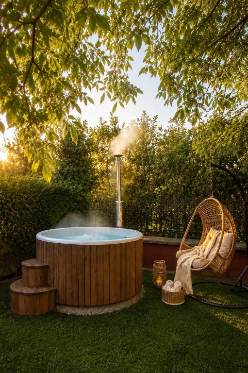 a hot tub in a yard with a chair and a fountain at CAL QuEROL Llac, Villa con jacuzzi y jardín en Puigcerdà centro in Puigcerdà