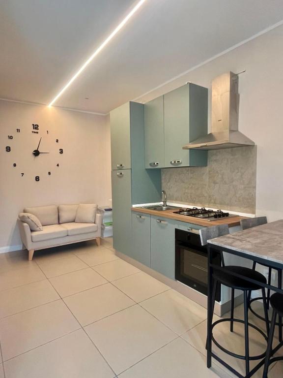 a kitchen with blue cabinets and a table and a couch at Caraceni Apartaments 2 in Castel di Sangro