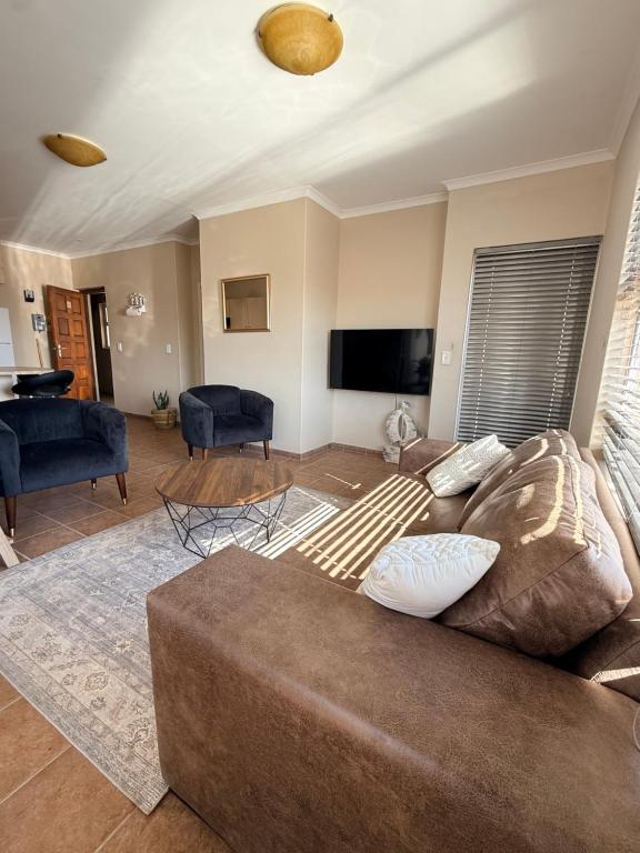 a living room with a couch and a flat screen tv at Praia Longa 4 in Rand Rifles