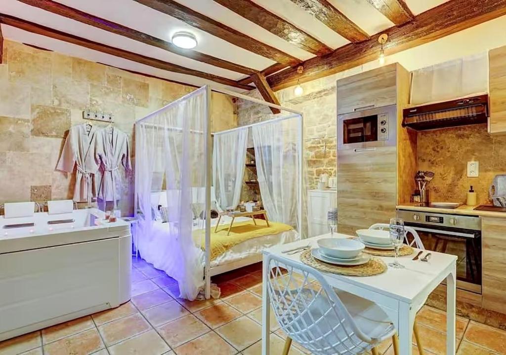 a kitchen with a white table and a kitchen with a stove at Bed & Spa - La Parenthese in Dijon