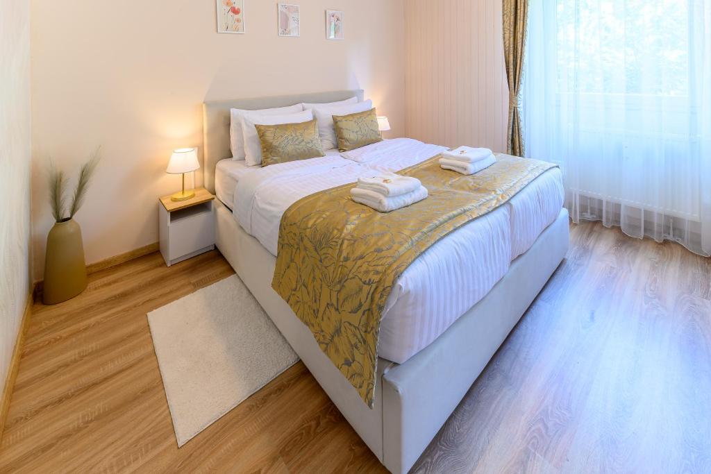 a bedroom with a large bed with towels on it at Kaposvár Deluxe Apartman in Kaposvár
