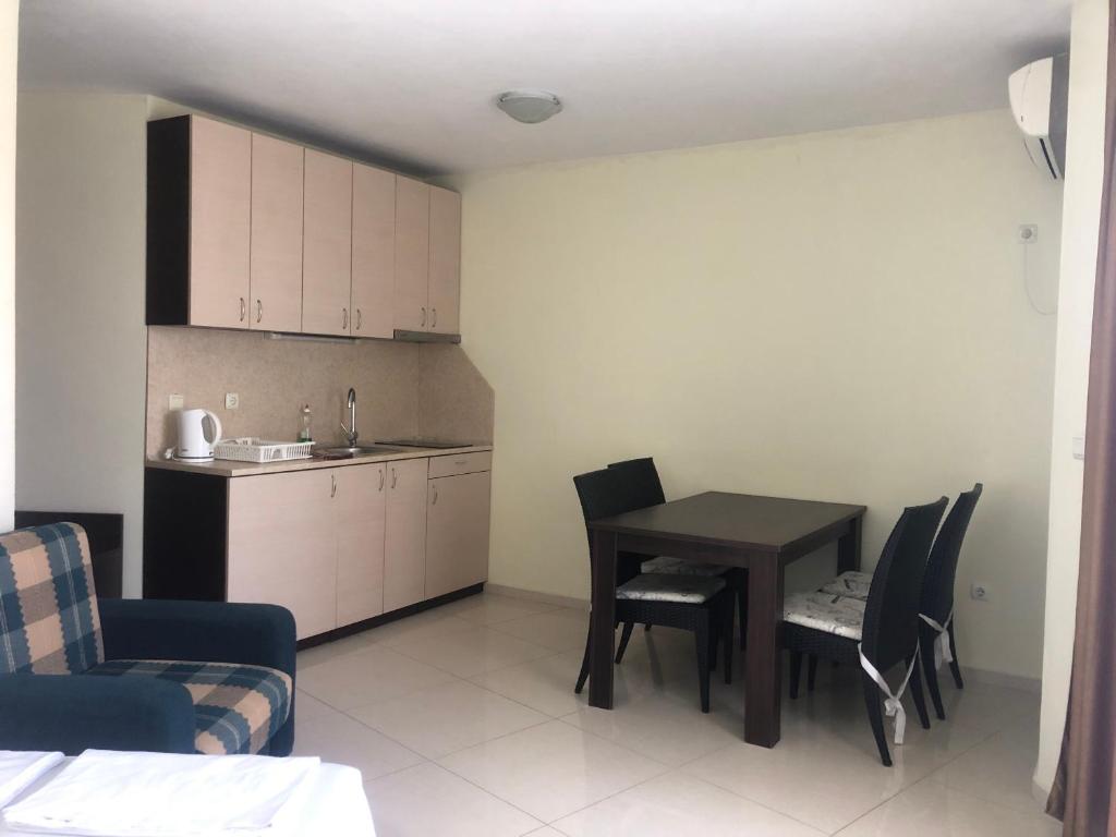 a living room with a table and chairs and a kitchen at Апартаменти Спас 2 in Sinemorets