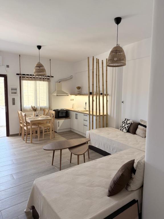 a white living room with two beds and a kitchen at Kanal Vstay #1 in Kithnos