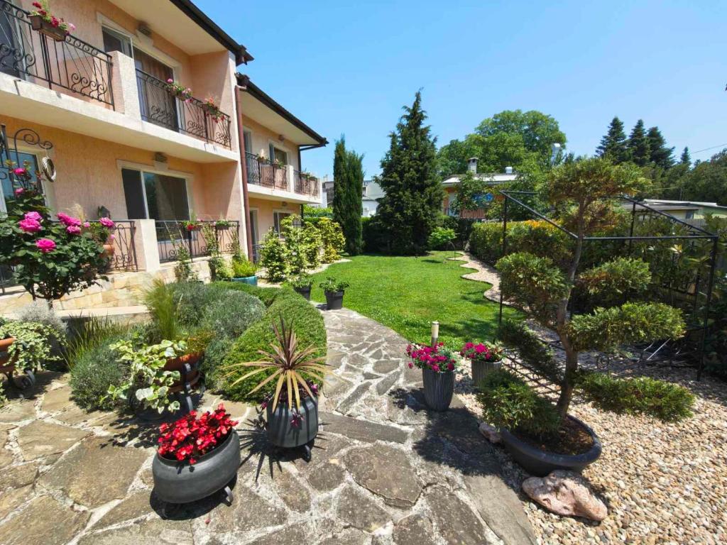 a garden with potted plants and a building at Motivi Hotel in Saints Constantine and Helena