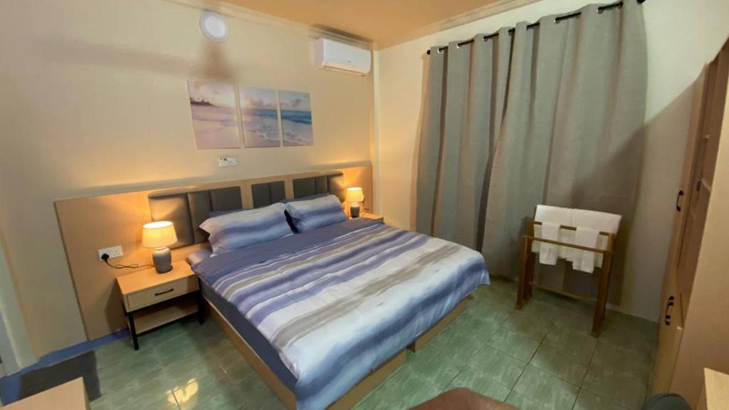 a bedroom with a bed and a table and two lamps at EcoWave Retreat- Muli in Muli