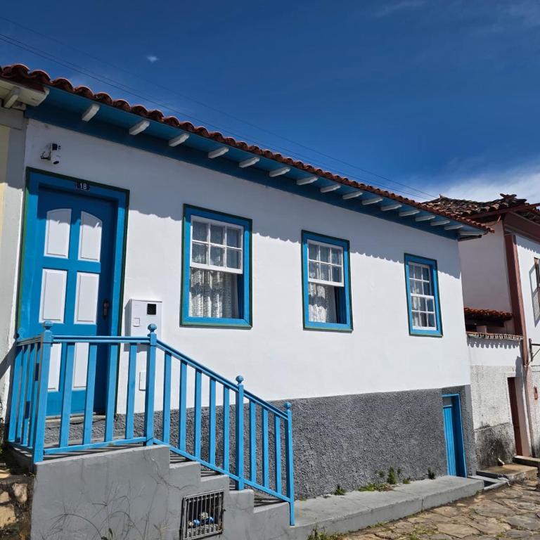 a white and blue house with a blue door at Casa Centro Exclusiva Diamantina in Diamantina