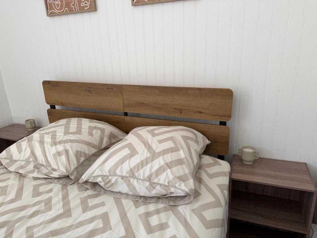 a bed with a wooden head board and two pillows at Le petit port de boucain in Port-de-Bouc