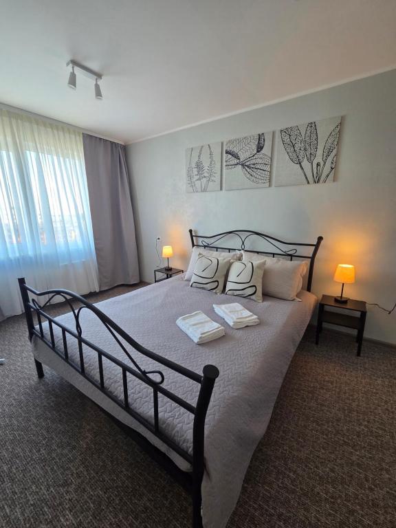 a bedroom with a large bed with two pillows at Lake Breeze Stay in Liepāja