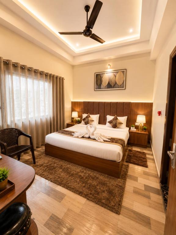 a bedroom with a large bed with a ceiling fan at Stay By Shree Dharan Inn Near Shree Ram Mandir Ayodhya in Ayodhya